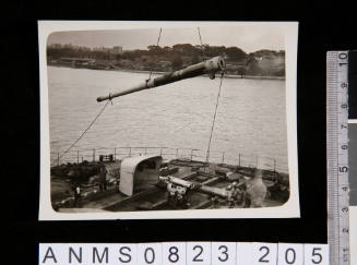 Hoisting a gun barrel on a naval ship