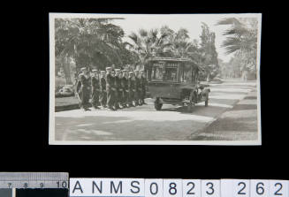 Silver gelatin photograph of group of uniformed sailors standing beside funeral car during funeral ceremony