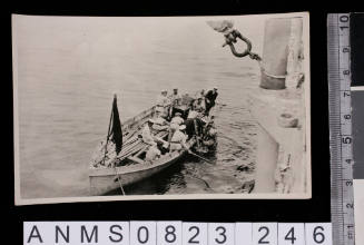 Silver gelatin photograph featuring group of sailors in small craft and diver