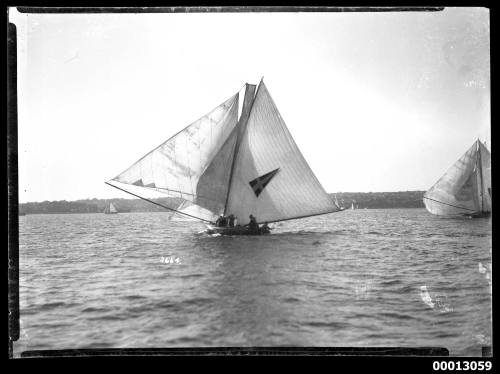 Yacht under sail on Sydney Harbour with a pennant emblem on the mainsail