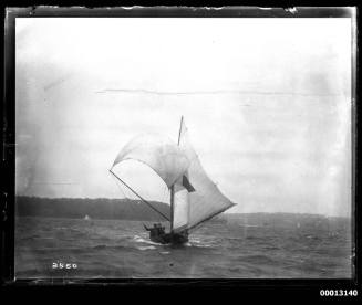 18-foot skiff on Sydney Harbour with a dark triangle emblem on the mainsail