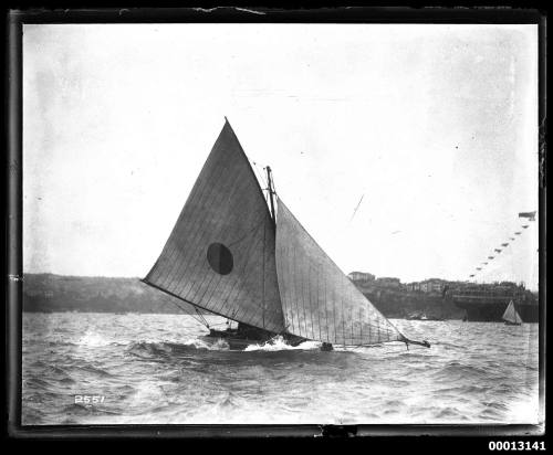 14' or 16' -foot skiff on Sydney Harbour with a bi-coloured circle emblem on the mainsail