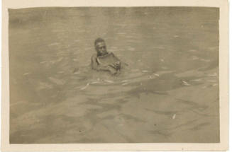 Photograph depicting a native man with net in water