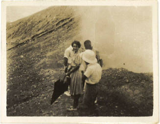 Photograph depicting a group of people at the rim of a volcano