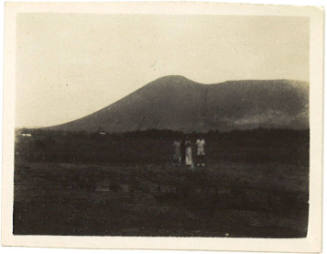Photograph depicting a group of people in front of a mountain or volcano