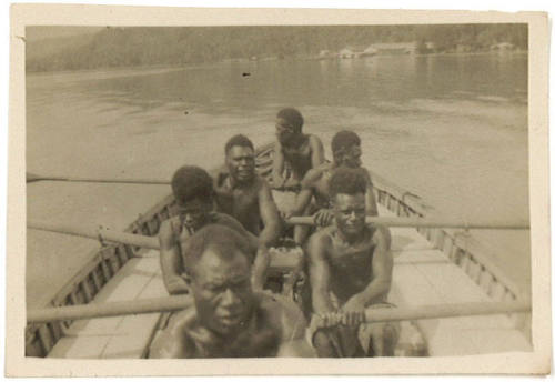 Photograph depicting six men rowing a boat