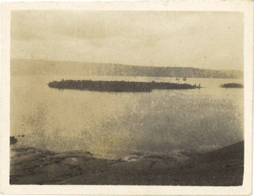 Photograph depicting a view from a volcanic coastline into a small bay