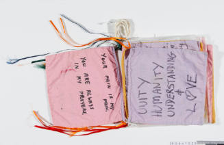 Rope of sixteen cotton square flags containing messages of peace and hope