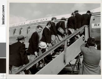 Members of a swimming team boarding a plane in London to Paris