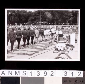 A group swimmers walking next to a pool