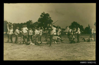 Photographic postcard men in protective clothing in a mock battle