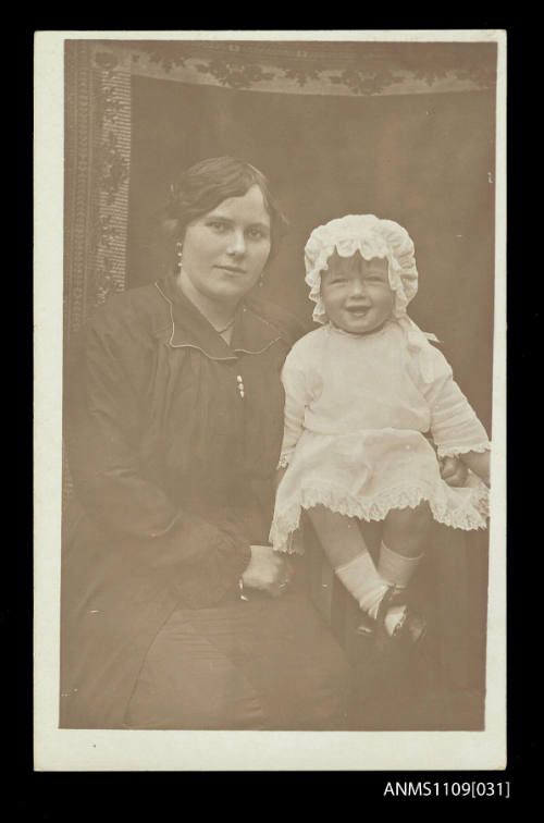 Photographic postcard of a young woman holding a small child