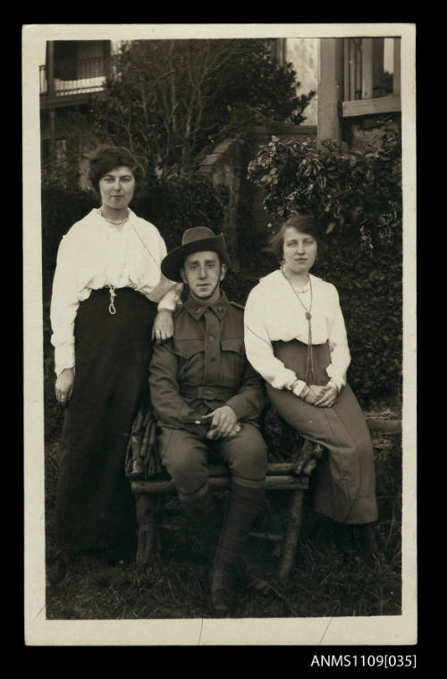 Photographic postcard of an Australian soldier with two women