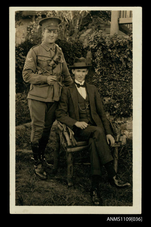 Photographic postcard of two men with one wearing military uniform