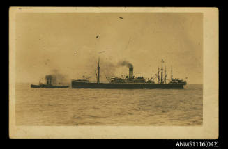Photograph of a single funnelled steam ship being pulled by a tug
