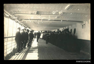 Scene on deck of unknown steam ship members of crew lined up against railing and also cabin walls