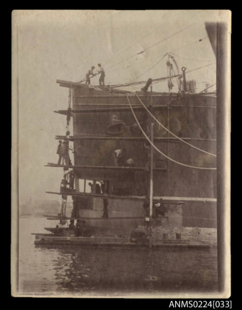 Photograph view of bow of ship with pontoon and scaffolding alongside, taken Morts dock, Sydney NSW