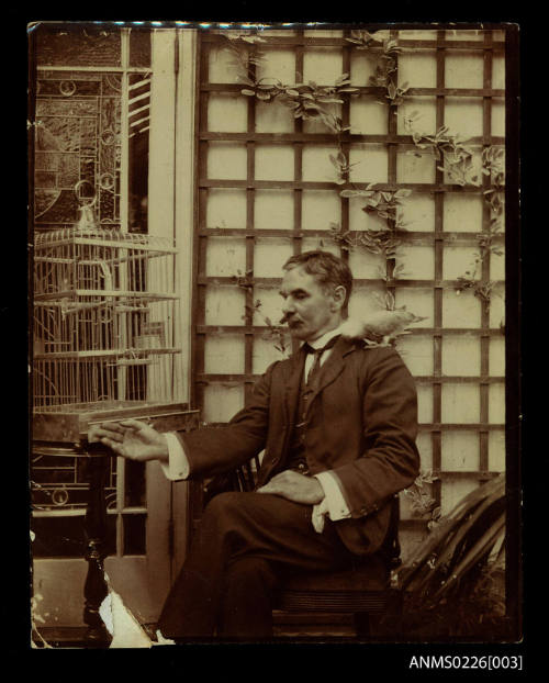 Centre, man seated, dark suit with waistcoat, tie, moustache [Captain McKilliam]