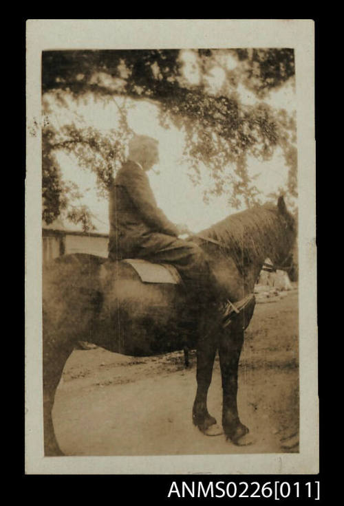 Man on horse, indistinct view from right of horse, man wearing dark suit, has grey hair. Smokes pipe, Captain mckilliam