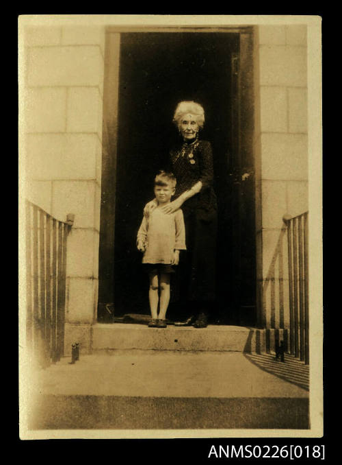 Elderly woman with young boy, woman has dark dress, grey hair