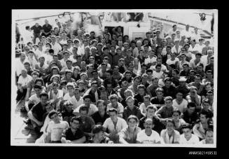 Crowd of people posed for photograph on board a ship
