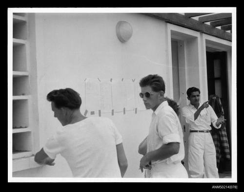 Young men consulting passenger list after the sinking of MV SKAUBRYN