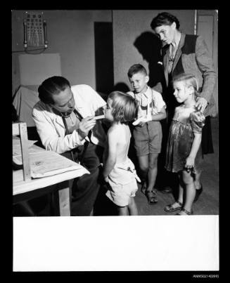Hungarian doctor, Antony Tamas, examining a Polish family about to migrate to USA 