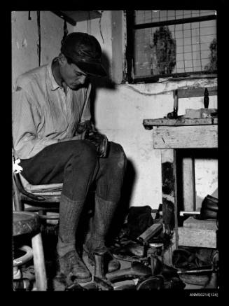 Hungarian refugees in the camp in Osijek maintain various types of repair shops. The materials are supplied by the camp and the repairs are done free-of-charge. In the cobbler shop Zoltan Egyedi, 20, a horse breeder from Baja, Hungary, soles a shoe. He, his wife and infant son, who was born 8 days before this picture, will soon leave for Australia