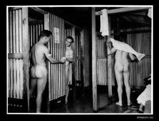 Men in shower area of the ablution facilities of reception centre