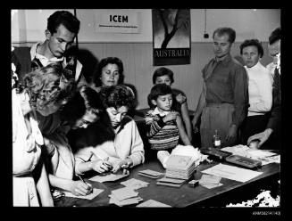 Men, women and children in line after vaccination at the ICEM Australian mission,