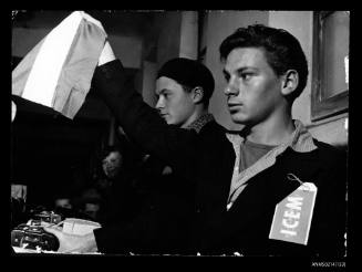 Young man holding a Hungarian flag at the baggage counter