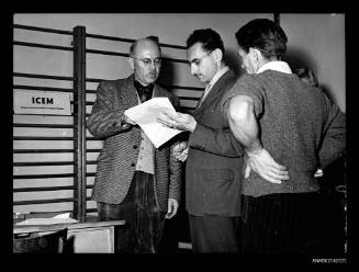 Three men discussing documents