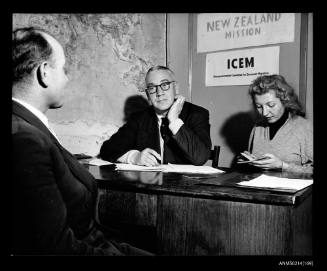 Man and woman interviewing a man at a desk