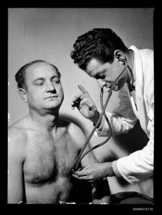 Doctor with stethoscope examing man