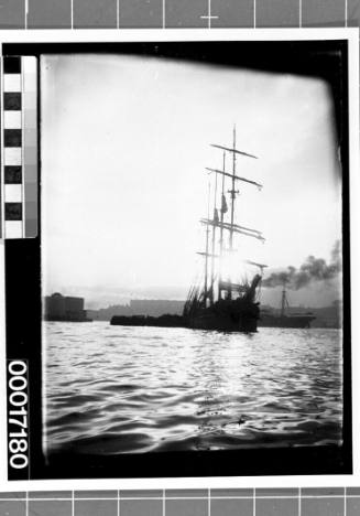 Bow view of a four-masted sailing ship moored in a harbour