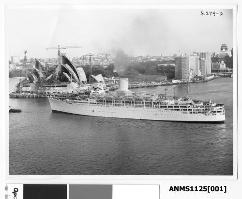 P&O passenger liner SS CHUSAN being towed by a tug past Bennelong Point. The ‘sails’ of the Sydney Opera House are seen being erected in the background.