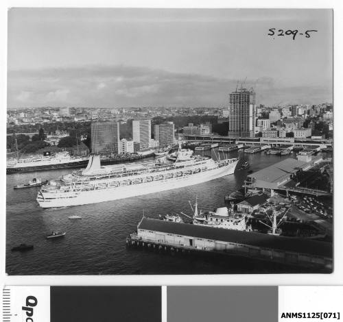 P&O liner CANBERRA preparing to berth at Circular Quay with a tugboat standing by