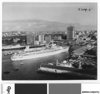 P&O liner CANBERRA preparing to berth at Circular Quay with a tugboat standing by